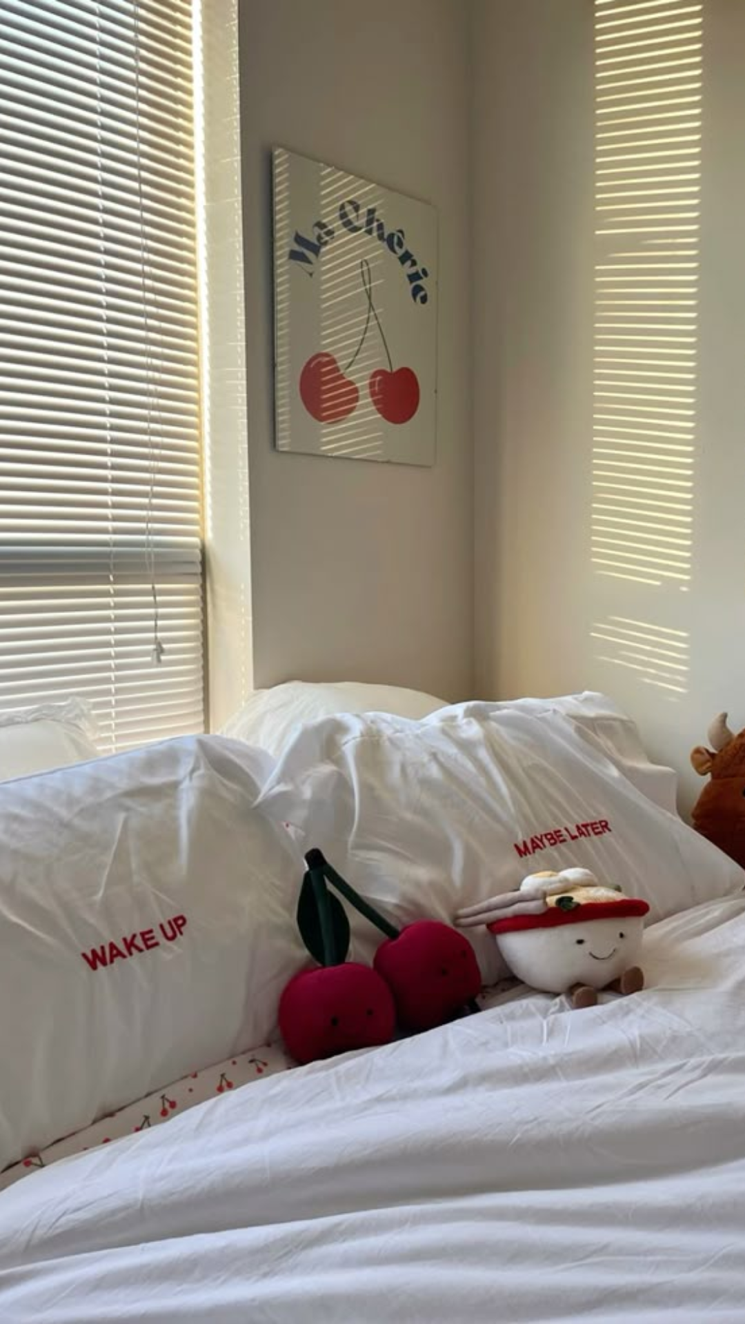 Quarto branco com alguns detalhes de cereja: pelúcia na cama e quadro na parede