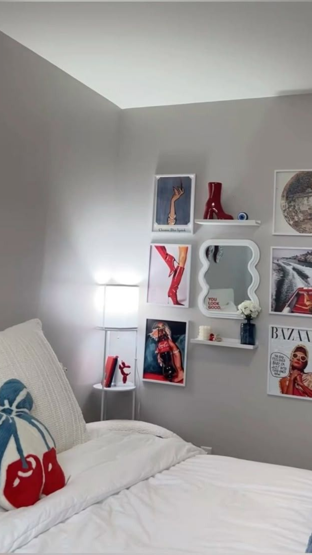 Quarto branco e verde com pelúcia em formato de cereja em cima da cama