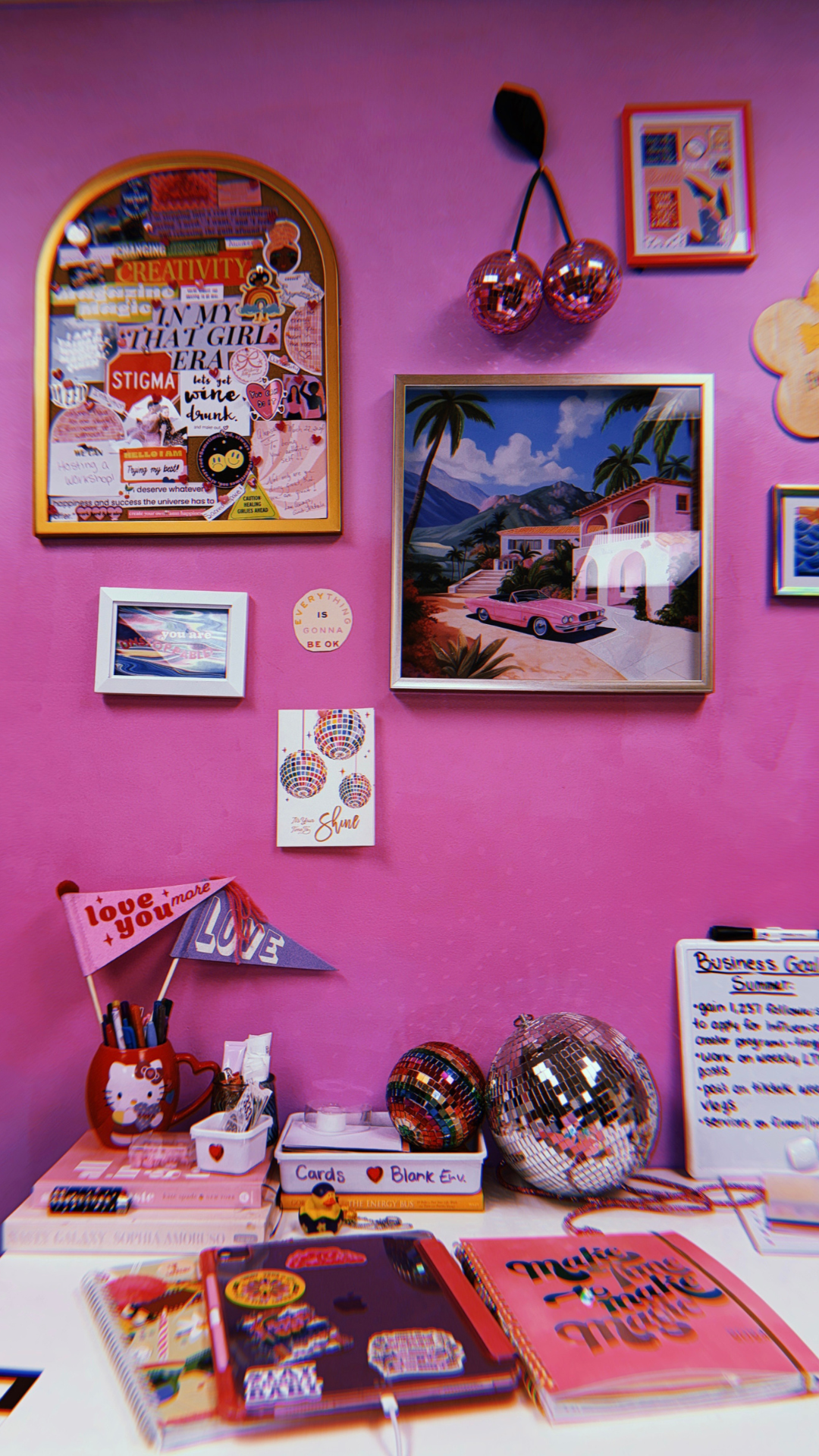 Parede cor de rosa com itens de decoração, sendo um deles uma cereja no estilo disco
