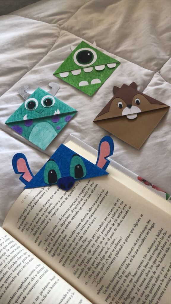 4 marca-páginas feitos com papel dobrado, com os desenhos do Stich, Sullyvan, Mike Wazowsky e um esquilo.