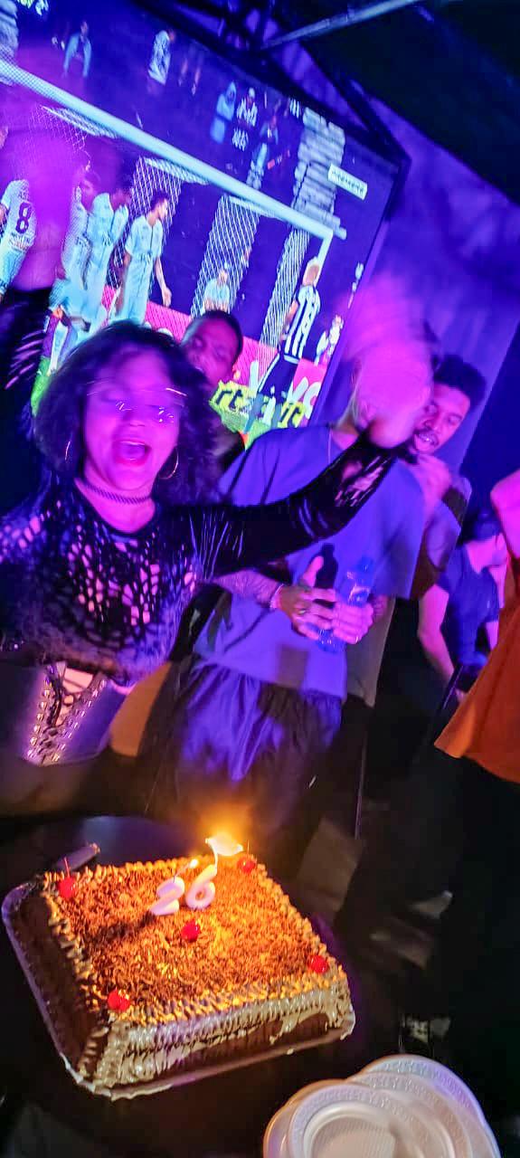 foto minha na comemoração do meu aniversário, cantando parabéns em frente ao bolo