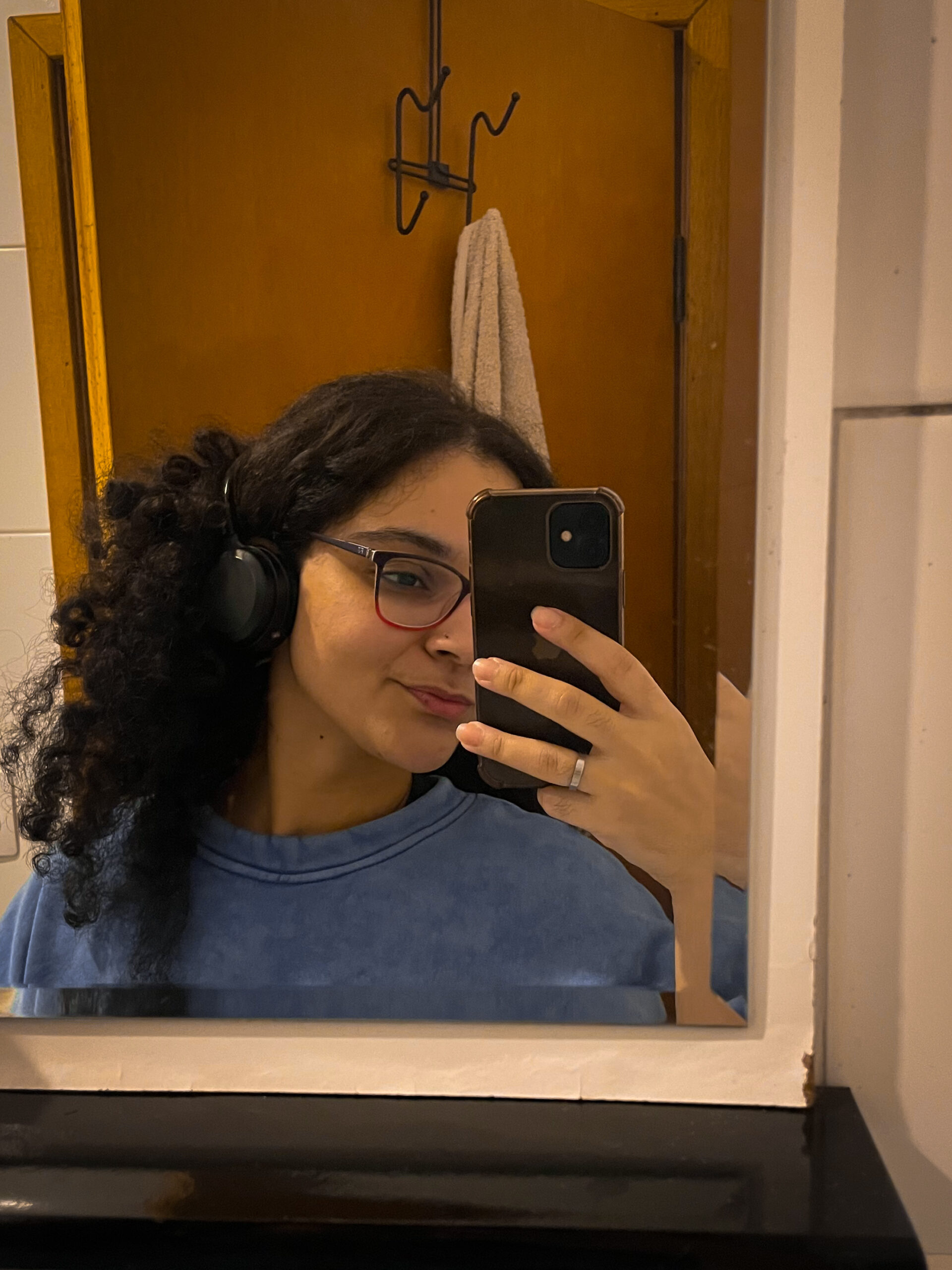 Selfie minha, tirada no espelho, usando uma blusa de frio azul.