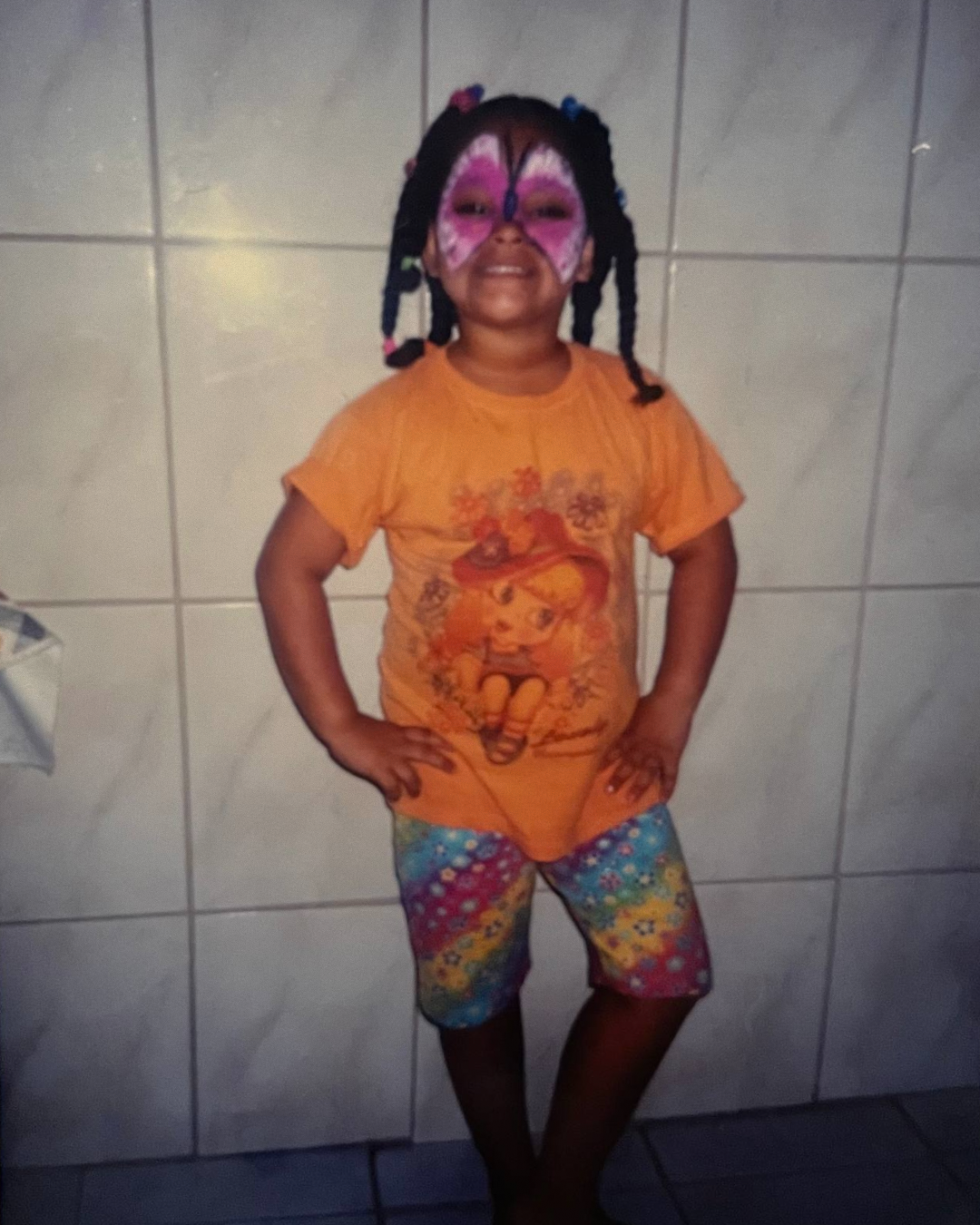Foto minha criança, com uma pintura facial de borboleta cor-de-rosa.